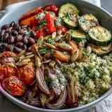 A colorful Veggie and Quinoa Power Bowl with roasted vegetables, beans, and a lemon dressing, served in a ceramic bowl.