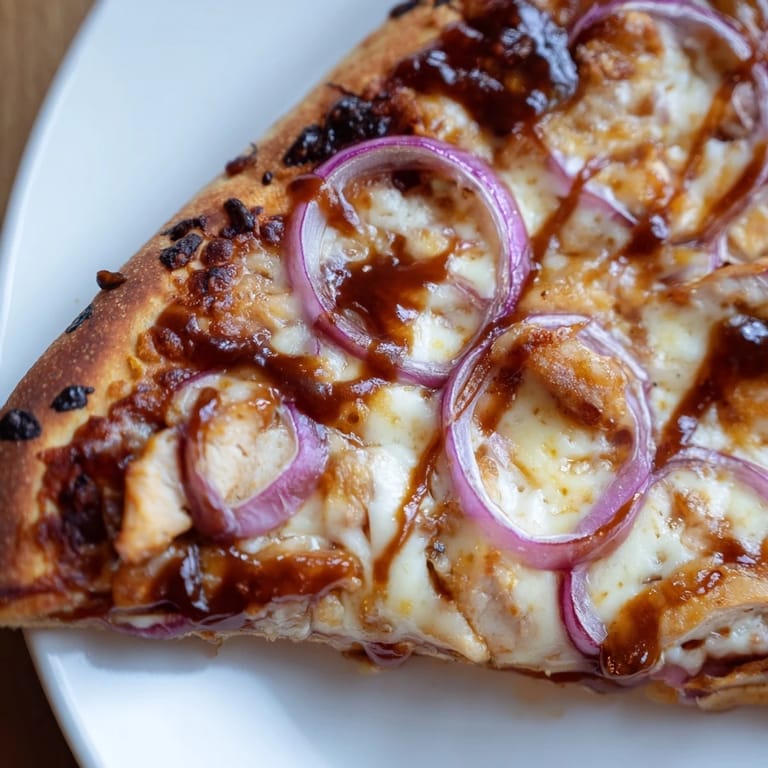 Homemade Chicken BBQ Pizza on a wooden board, featuring savory toppings and a crispy, golden-brown edge ready to serve.