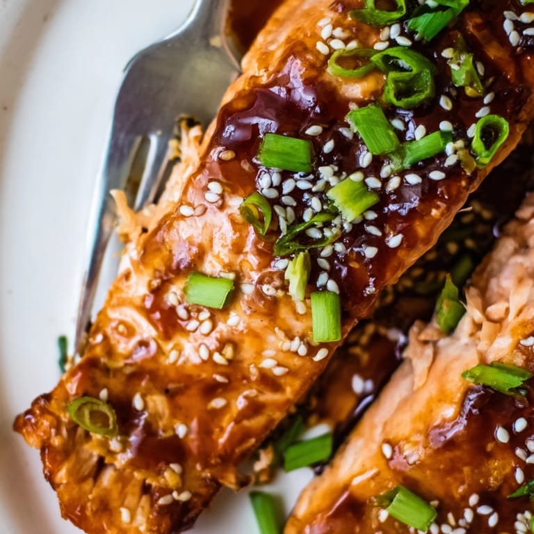 Succulent honey garlic salmon fillets served alongside fluffy steamed rice and vibrant seasonal vegetables.