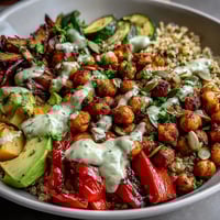 Golden roasted vegetables and spiced chickpeas mound over fluffy quinoa in this vibrant Chickpea Power Bowl, finished with creamy tahini sauce.